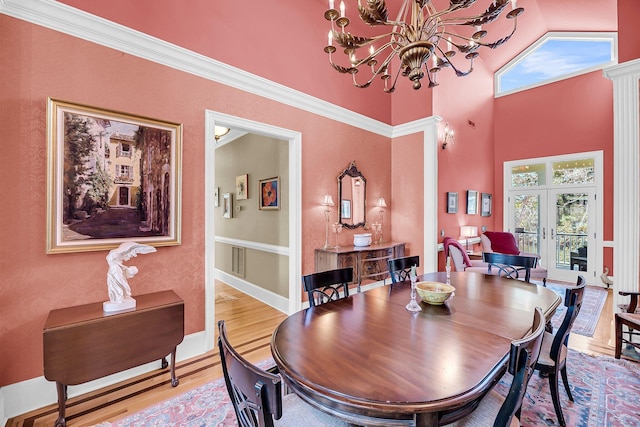 dining room with light wood-style floors, french doors, baseboards, and an inviting chandelier