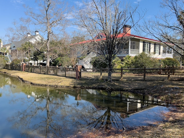 view of dock featuring a water view and fence