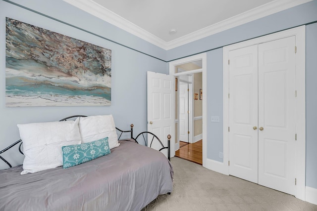 bedroom with ornamental molding, a closet, and baseboards