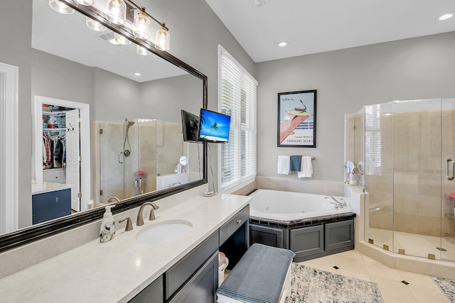 full bathroom featuring vanity, a spacious closet, tile patterned floors, a tub with jets, and a stall shower