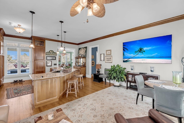 kitchen featuring crown molding, a kitchen breakfast bar, a center island, and light wood-style floors