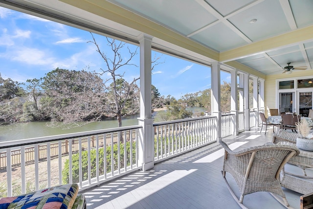 sunroom with a water view, coffered ceiling, beam ceiling, and a ceiling fan