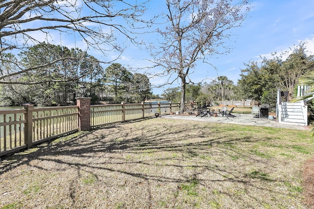 view of yard featuring fence and a patio