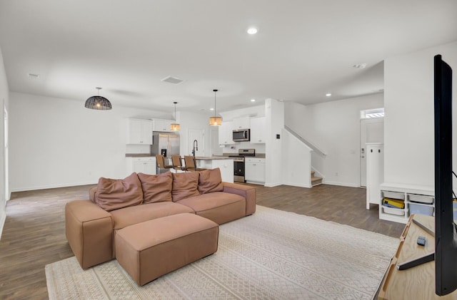 living room with stairway, baseboards, recessed lighting, and wood finished floors