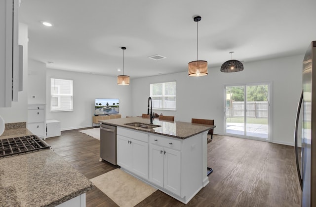 kitchen with dark wood-style flooring, a sink, stainless steel appliances, open floor plan, and a healthy amount of sunlight