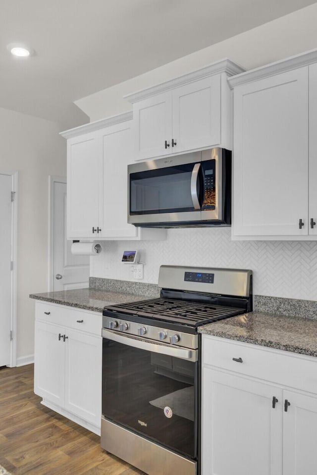 kitchen featuring backsplash, dark wood-style floors, stainless steel appliances, recessed lighting, and white cabinetry