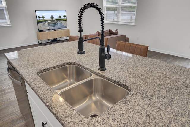 room details with baseboards, light stone countertops, and a sink