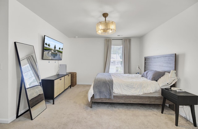 bedroom with baseboards and light carpet