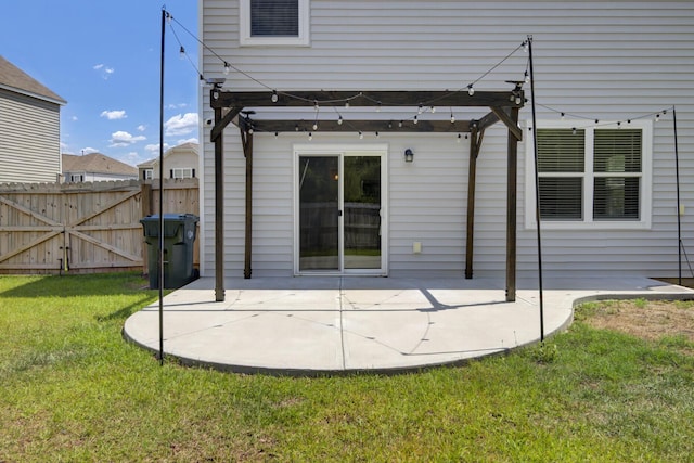 rear view of property featuring a lawn, fence, and a patio