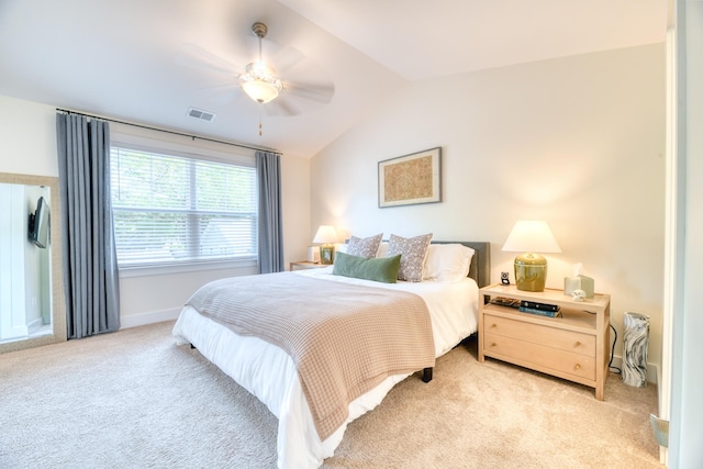 bedroom featuring baseboards, visible vents, light colored carpet, and vaulted ceiling