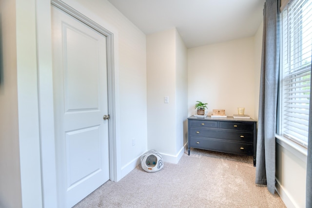 bedroom with light colored carpet and baseboards