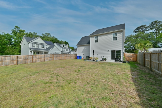 back of property featuring a yard, a patio area, and a fenced backyard