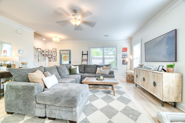 living area featuring crown molding, stairway, baseboards, ceiling fan, and light wood-style floors