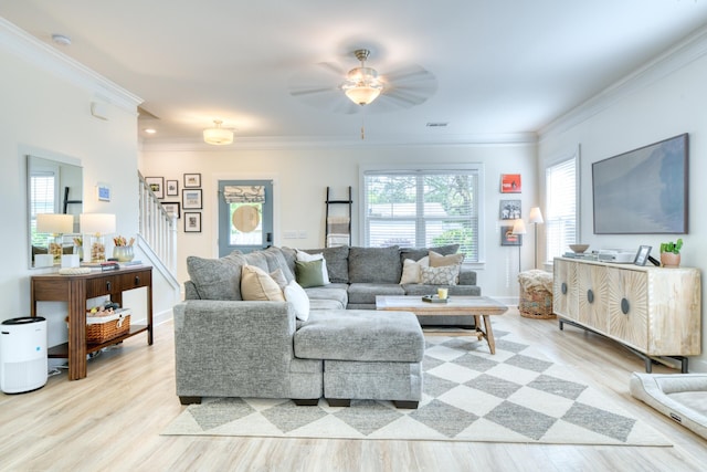 living room with stairway, ceiling fan, crown molding, baseboards, and light wood-style floors