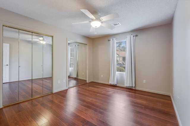 7945 Parklane Ct Unit C, North Charleston, SC 29418 - unfurnished bedroom with wood-type flooring, a textured ceiling, multiple closets, baseboards, and a ceiling fan