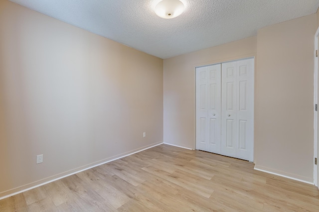 7945 Parklane Ct Unit C, North Charleston, SC 29418 - unfurnished bedroom with light wood-type flooring, a textured ceiling, a closet, and baseboards