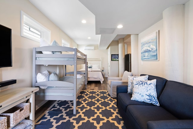 bedroom featuring an AC wall unit, wood finished floors, and recessed lighting