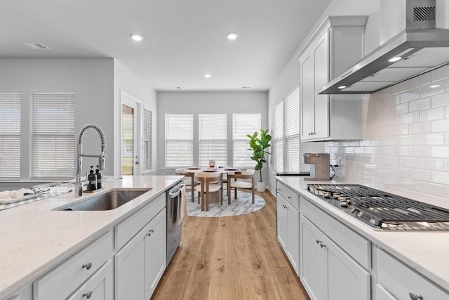 1107 Bellwether Ln, Summerville, SC 29485 - kitchen with wall chimney exhaust hood, appliances with stainless steel finishes, light wood-style floors, recessed lighting, and backsplash