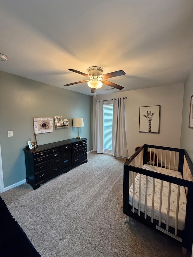 bedroom featuring carpet, ceiling fan, and a nursery area