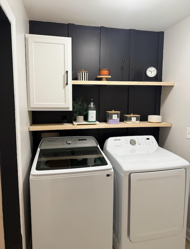 laundry area with washer and dryer and cabinets