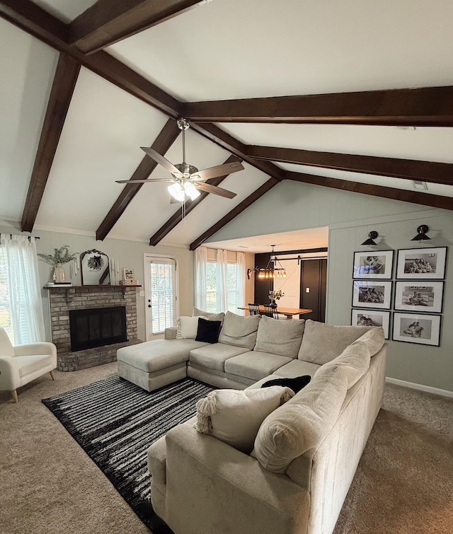 carpeted living room featuring lofted ceiling with beams, ceiling fan with notable chandelier, and a brick fireplace