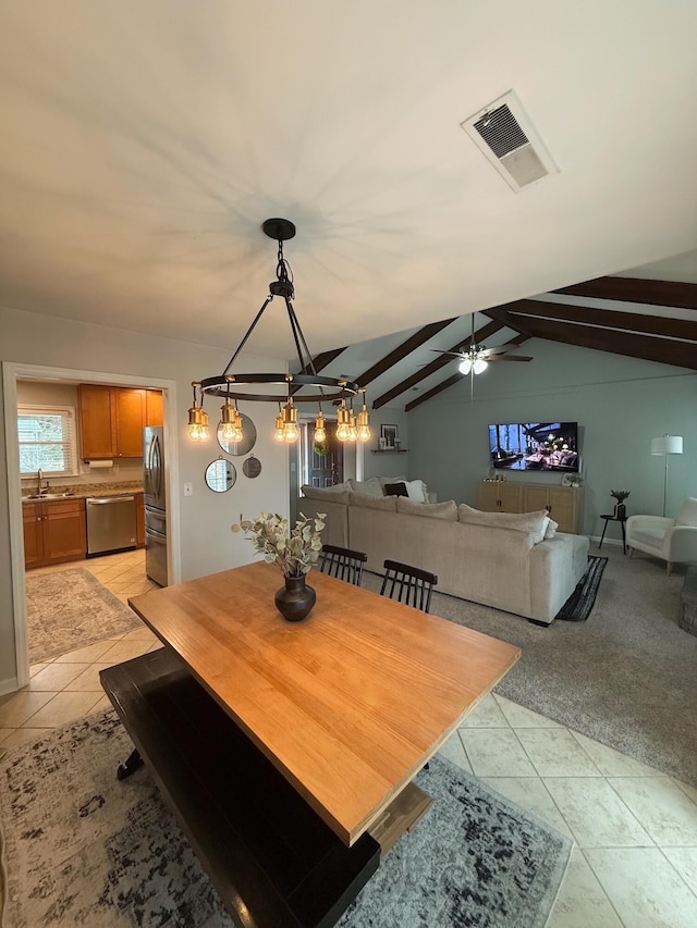 tiled dining space featuring sink, lofted ceiling with beams, and ceiling fan with notable chandelier