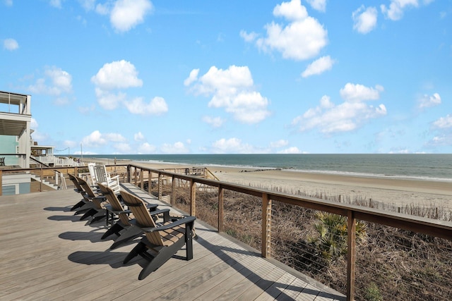 wooden deck with a water view and a beach view