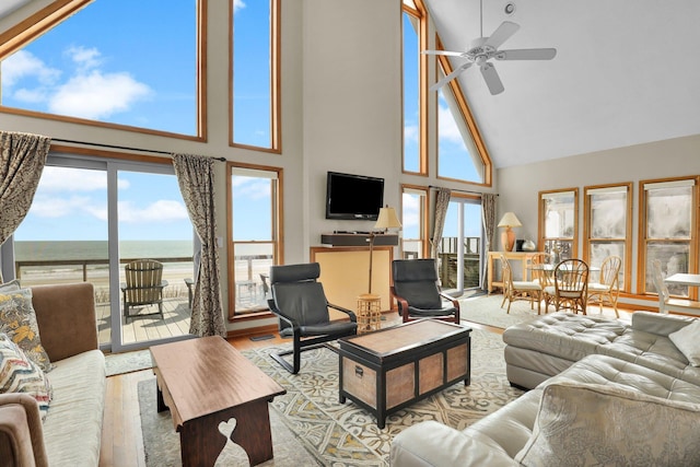 living area with ceiling fan, high vaulted ceiling, and wood finished floors