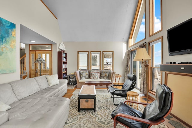 living area featuring stairs, high vaulted ceiling, and wood finished floors