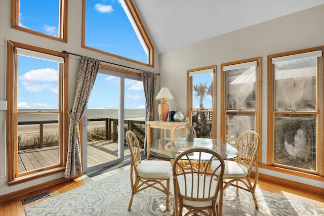 sunroom featuring visible vents and vaulted ceiling