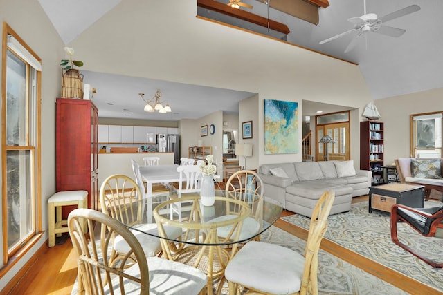 dining space featuring ceiling fan, high vaulted ceiling, and wood finished floors