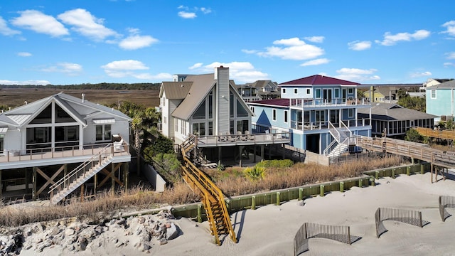 rear view of house with stairway, a chimney, and a residential view