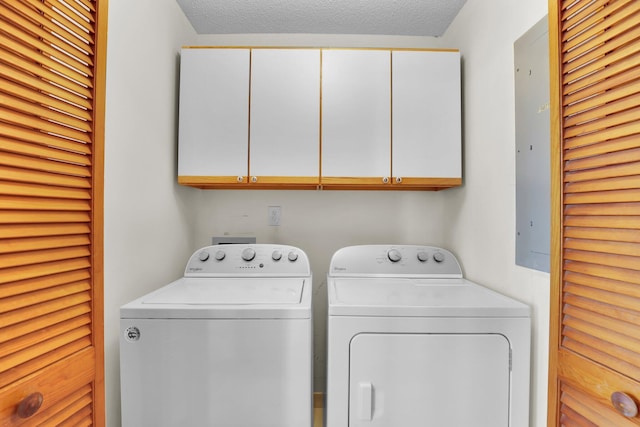 laundry area with cabinet space, independent washer and dryer, and a textured ceiling