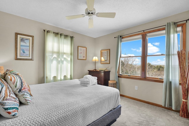 carpeted bedroom featuring ceiling fan, a textured ceiling, and baseboards