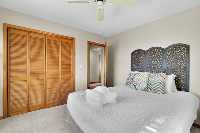 bedroom with ceiling fan, carpet floors, a closet, and a textured ceiling