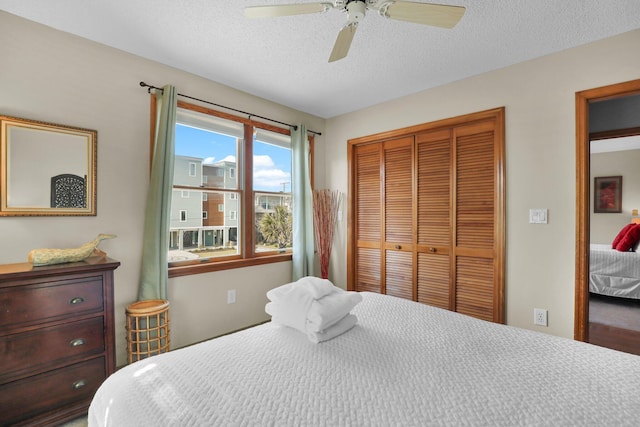 bedroom featuring a textured ceiling, a ceiling fan, and a closet