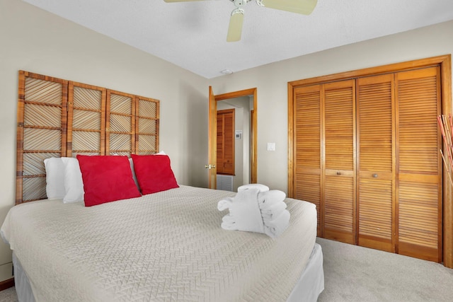 bedroom with a ceiling fan, carpet, a closet, and a textured ceiling