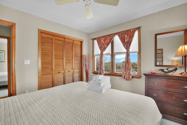 bedroom featuring a textured ceiling, ceiling fan, and a closet