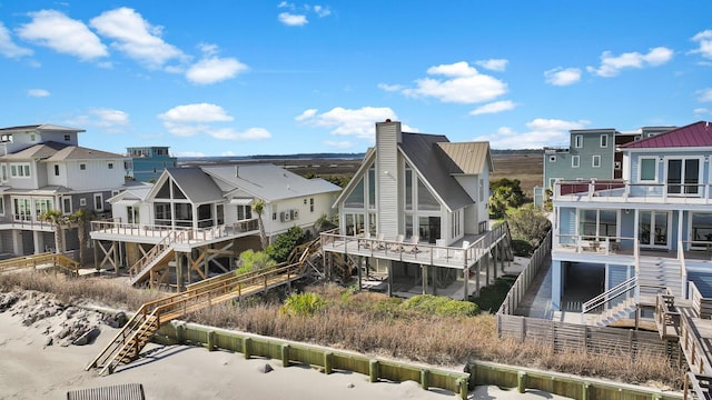 rear view of house featuring a residential view, a chimney, and stairway