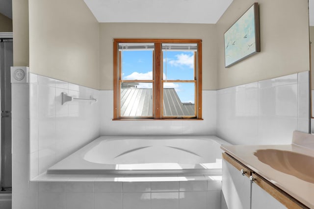 bathroom with a garden tub and vanity