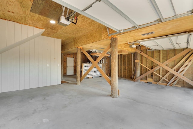 garage featuring wood walls and a garage door opener