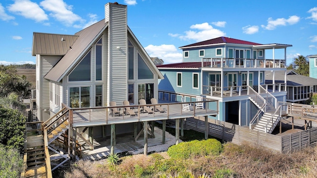 back of property with stairs, a chimney, metal roof, and a patio