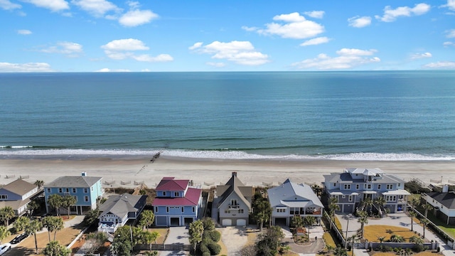 drone / aerial view featuring a residential view, a water view, and a beach view