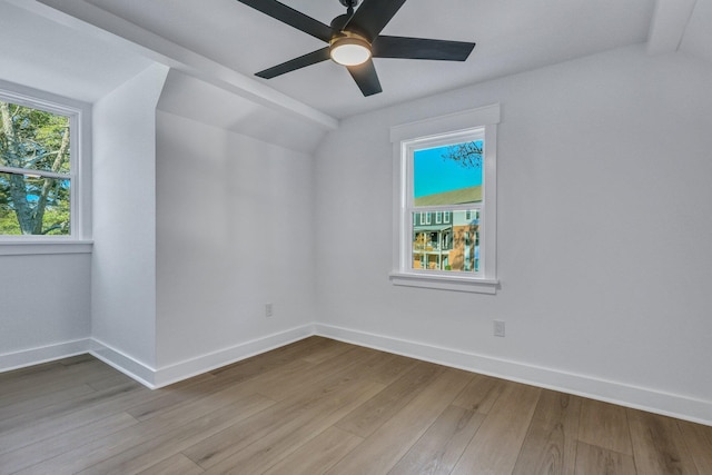 empty room with vaulted ceiling with beams, light hardwood / wood-style flooring, and ceiling fan