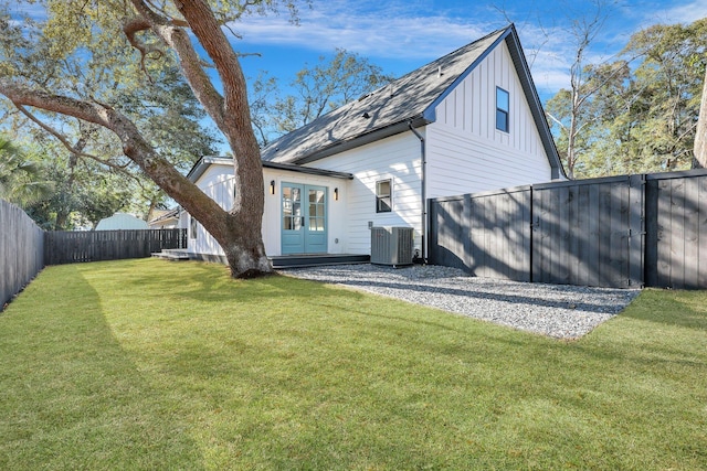 back of house featuring a lawn and central AC