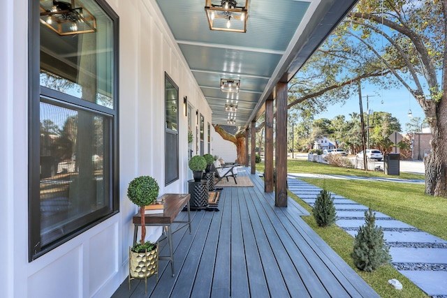 wooden deck featuring a lawn and a porch