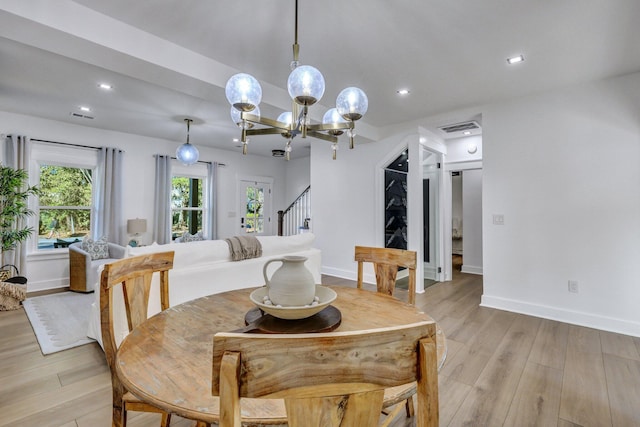 dining room with a notable chandelier and light wood-type flooring