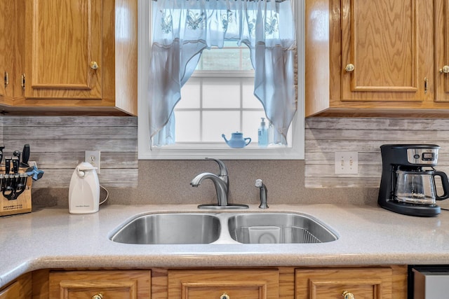 kitchen featuring a wealth of natural light, decorative backsplash, and sink