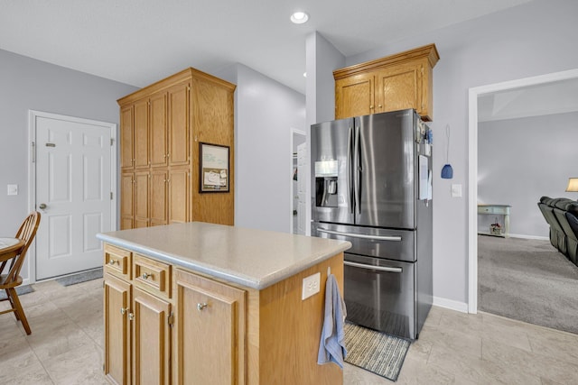 kitchen featuring stainless steel refrigerator with ice dispenser, light colored carpet, and a kitchen island