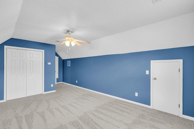 bonus room with ceiling fan, a textured ceiling, carpet flooring, and vaulted ceiling